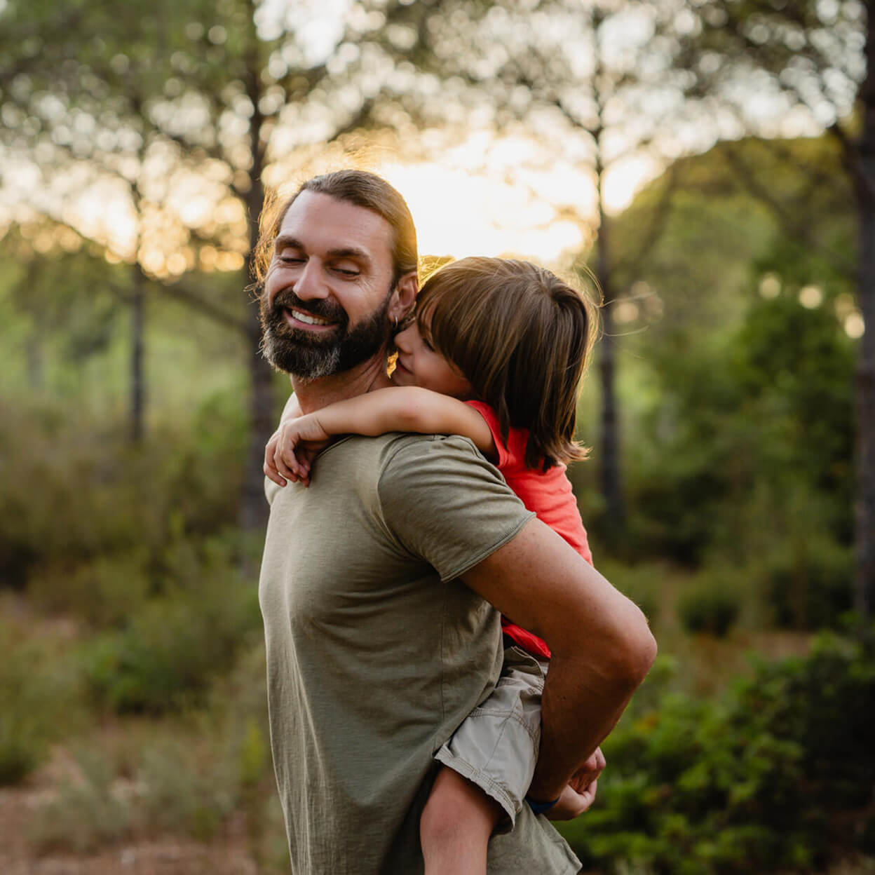 A dad carries his daughter on his back